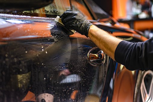 person cleaning a car after dent removal